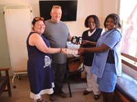 Two individuals handing over medical equipment to Zambian hospital representatives