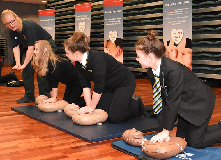 Schoolchildren learning CPR