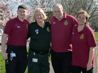 Three Community First Responders, in uniform, and a YAS member of staff