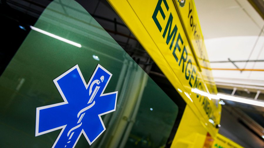 Close-up of an ambulance, the Star of Life is in the foreground.