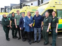 Patient standing next to the ambulance crew who saved her life